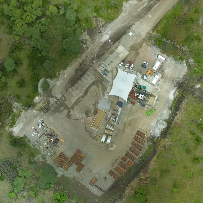 Aerial view of a construction site organised among surrounding greenery.