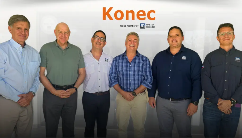 Six Konec and Master Drilling representatives standing together beneath the Konec logo.