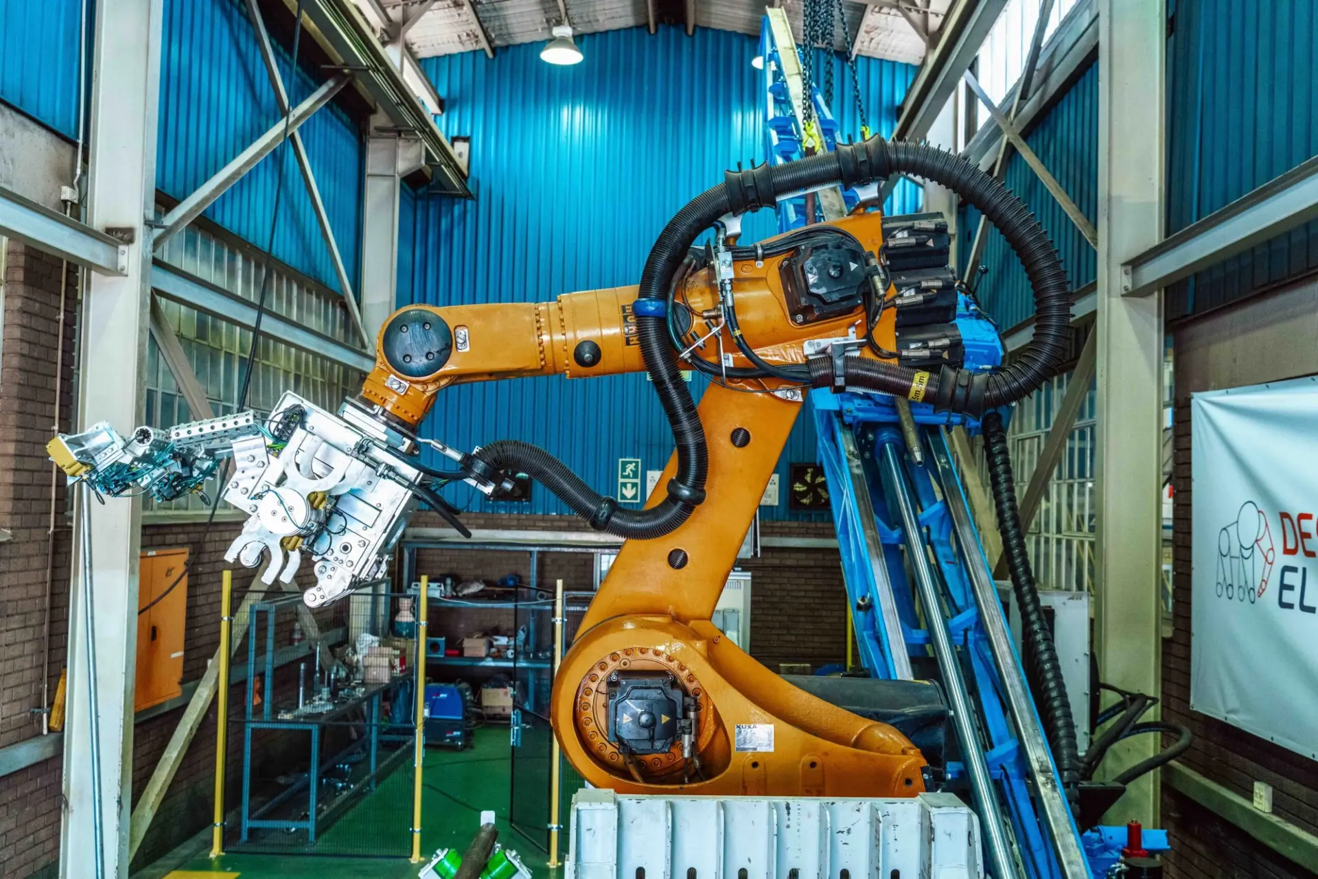 Automated drilling equipment mounted on an industrial robotic arm.