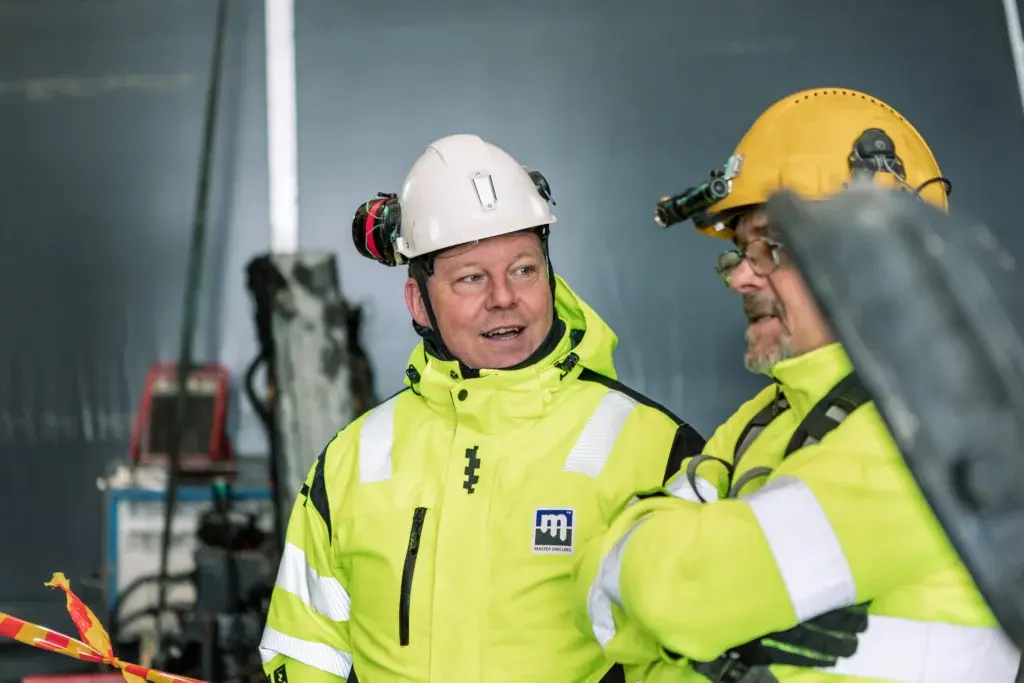 Master Drilling crew beside large-scale drilling equipment
